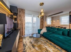 a living room with a green couch and a table at Deluxe Apartment Bono in Sinj