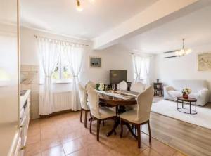 a kitchen and living room with a table and chairs at Villa Pax in Studenci