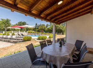 a patio with a table and chairs and a pool at Villa Pax in Studenci