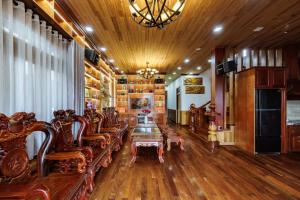 a living room with wooden furniture and a chandelier at AT House Dalat - The Pine Concept in Da Lat