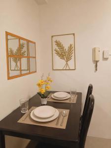 a dining room table with plates and utensils on it at Shore Residences 1 tower D in Manila