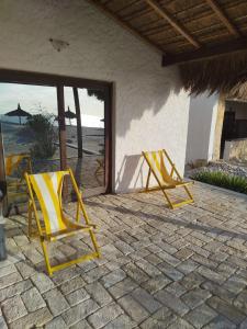 two yellow chairs sitting on a patio near the beach at Castello in Anakao +1 photo