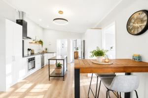 a kitchen and dining room with a table and a clock at The Nelson Lookout - Mountain Views & City Centre Living in Nelson +10 photos
