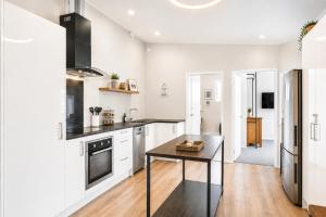 a kitchen with white cabinets and a table at The Nelson Lookout - Mountain Views & City Centre Living in Nelson