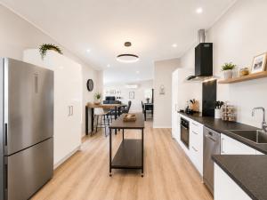 a kitchen with a stainless steel refrigerator and a counter at The Nelson Lookout - Mountain Views & City Centre Living in Nelson