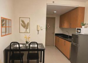 a kitchen with a table and chairs and a refrigerator at Shore Residences 1 tower D in Manila