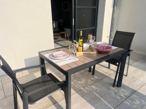 a dining table with a bottle of wine and two chairs at Schlof'zheim in Friesenheim