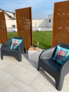 two chairs sitting on a patio with a table at Schlof'zheim in Friesenheim