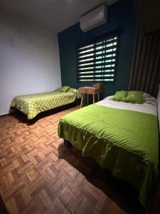 a bedroom with two beds and a table and a window at Casa en Tepic in Tepic +13 photos