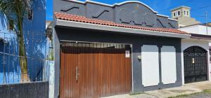 a house with a wooden gate and a building at Casa en Tepic in Tepic