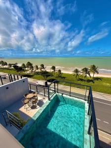 a swimming pool with a view of the beach at G5 Beach Flat Intermares 304 in Cabedelo