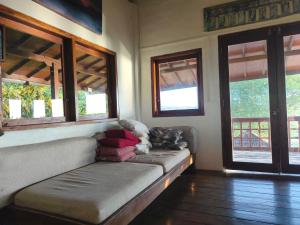 a couch with a teddy bear on it in a room with windows at Maluk House in Taliwang