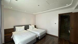 a hotel room with two beds and a bathroom at The Dome Grand in Ninh Lão