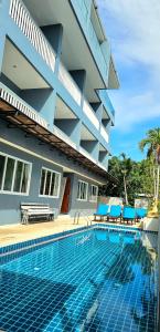 a hotel with a swimming pool in front of a building at AM Surin Place in Surin Beach