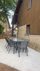 a glass table and chairs in front of a building at Maison familiale in La Souterraine