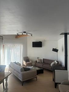 a living room with two couches and a tv at Maison familiale in La Souterraine