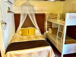 a bedroom with two bunk beds with yellow pillows at Dar Yasmine in Pantai Cenang +55 photos