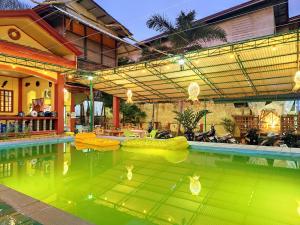 a swimming pool with a large green pool at Amwani Garden Pool & Kubo in Puerto Princesa City