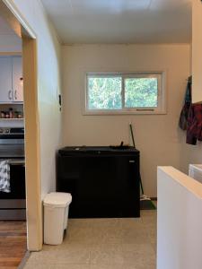 a kitchen with a black refrigerator and a window at Husie by die see in Tahsis