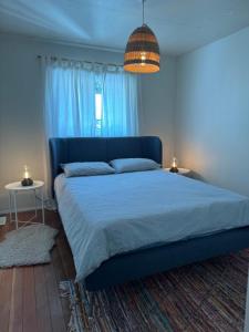 a bedroom with a large bed with a blue bedspread at Husie by die see in Tahsis