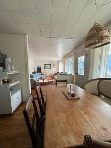 a dining room and living room with a table and chairs at Husie by die see in Tahsis
