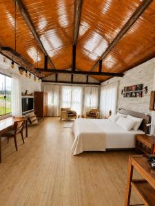 a large bedroom with a bed and a living room at Celeiro in Campina Grande do Sul