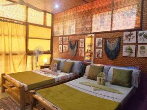 a bedroom with two beds and a couch at Amwani Garden Pool & Kubo in Puerto Princesa City +132 photos