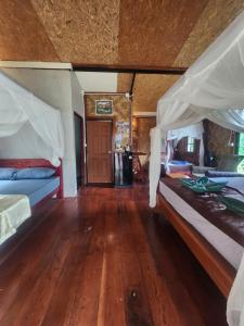 a bedroom with two beds and a wooden floor at Mook Bamboo Bungalows in Ko Mook