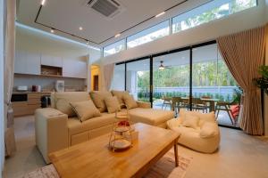 a living room with a couch and a table at Radarin Villa in Ban Khao Kloi