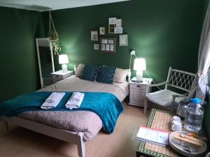 a green bedroom with a bed and a chair at Muddy Puddles Farm in Kovachevets +33 photos