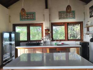 a kitchen with a counter top and two windows at Maluk House in Taliwang