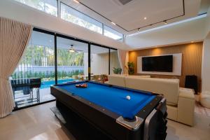 a pool table in a living room with a tv and a pool table at Radarin Villa in Ban Khao Kloi