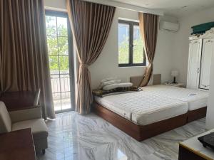 a bedroom with a bed and two windows at The F House in Danang +6 photos