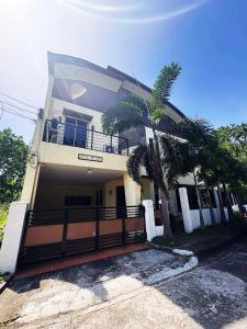 a house with a palm tree in front of it at The Transient Villa Hotel and Suites in Cordova