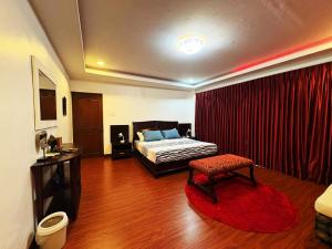 a bedroom with a bed and a red curtain at The Transient Villa Hotel and Suites in Cordova +21 photos
