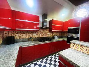 a kitchen with red cabinets and a checkered floor at The Transient Villa Hotel and Suites in Cordova