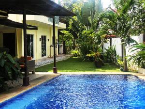 a swimming pool in front of a house at The Transient Villa Hotel and Suites in Cordova