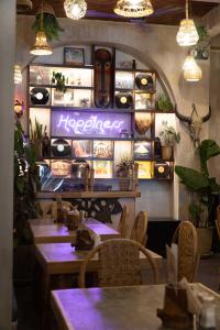 a restaurant with tables and chairs and a sign on the wall at Happiness Hostel El Nido in El Nido +32 photos