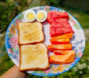 a plate of food with eggs and toast and vegetables at Jonaki Shantiniketan in Shānti Niketan