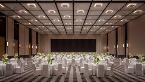 a conference room with white tables and chairs and a screen at Kimpton Nine Trees Shanghai by IHG in Shanghai +80 photos