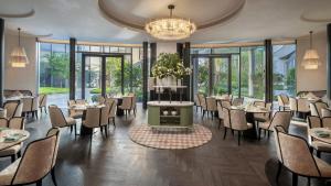 a dining room with tables and chairs and a chandelier at Kimpton Nine Trees Shanghai by IHG in Shanghai