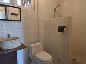 a bathroom with a toilet and a sink at Maluk House in Taliwang +5 photos
