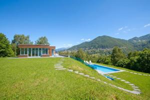 a large yard with a swimming pool and a house at Villa Intelvi in Castiglione dʼIntelvi