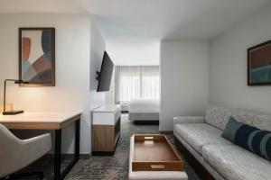 a living room with a couch and a desk and a bed at SpringHill Suites Dallas Arlington North in Arlington
