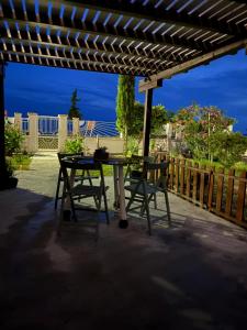 a picnic table and a chair under a pergola at Aether House Αιθήρ in Toroni