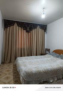 a bedroom with a bed and a window with curtains at Сдается дача in Balqash