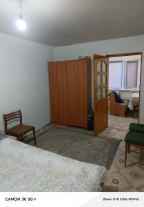 a bedroom with a bed and a wooden cabinet at Сдается дача in Balqash