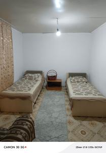 two beds sitting in a room with at Сдается дача in Balqash +22 photos