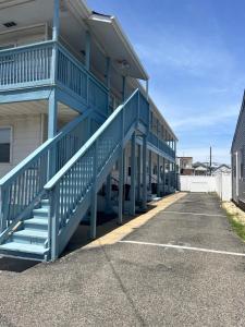 a building with blue stairs in a parking lot at Cozy Condo in Seaside Heights