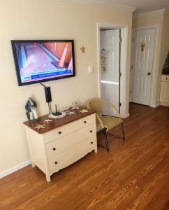 a room with a dresser with a tv on the wall at Cozy Condo in Seaside Heights +1 photo